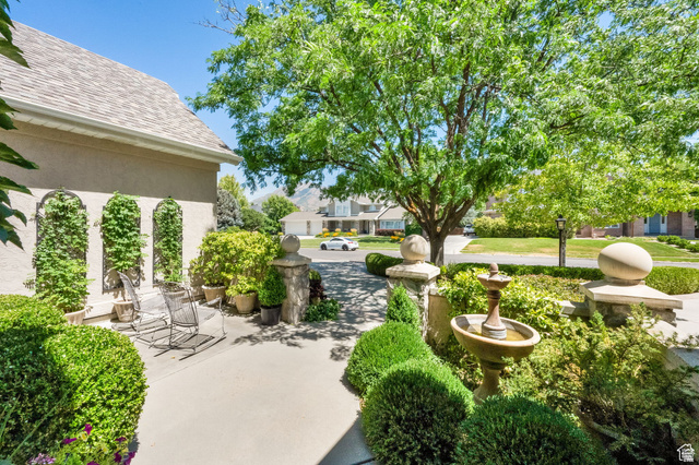 7740 Keswick Road Sandy, UT 84093 - Photo 7 of 74 Manicured landscaping featuring a stone fountain and mature trees