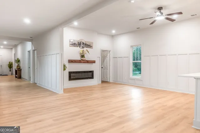 a view of an empty room with wooden floor and a fireplace