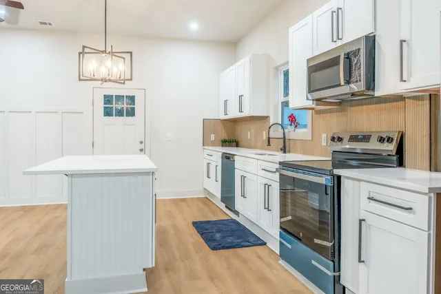 a large kitchen with cabinets and stainless steel appliances