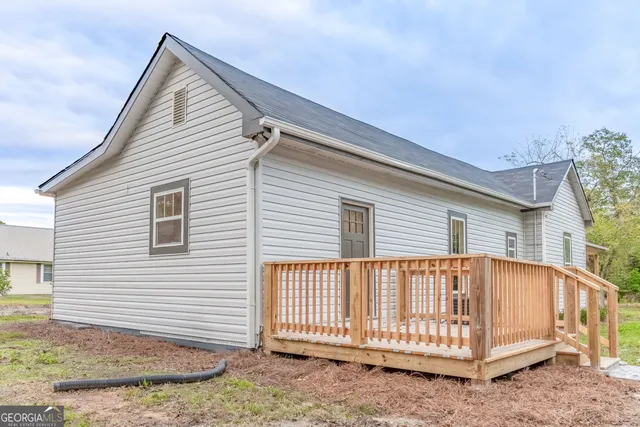 a backyard of a house with table and chairs