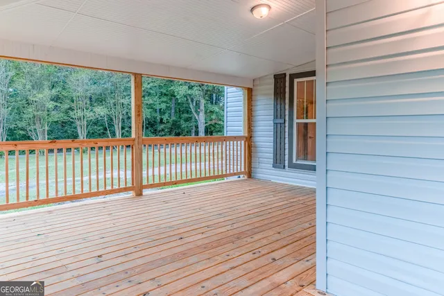 a view of a hallway with wooden floor and a potted plant