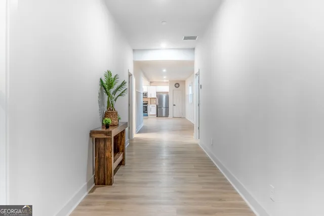 a view of hallway with wooden floor