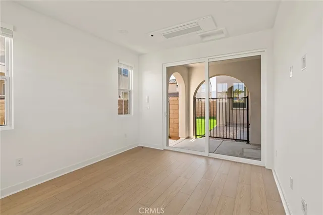 an empty room with wooden floor and a ceiling fan
