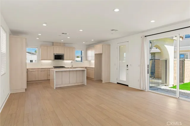 a large white kitchen with a refrigerator a stove top oven and white kitchen with cabinets