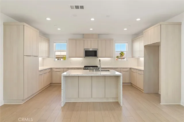 a kitchen with a sink stainless steel appliances and white cabinets