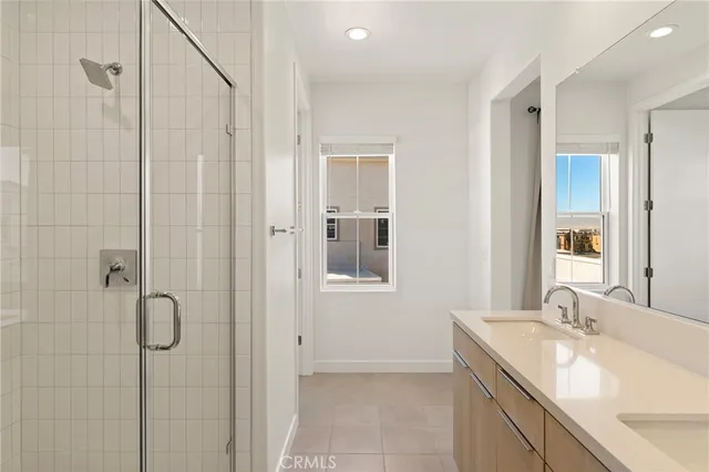 a bathroom with a granite countertop sink a mirror and shower