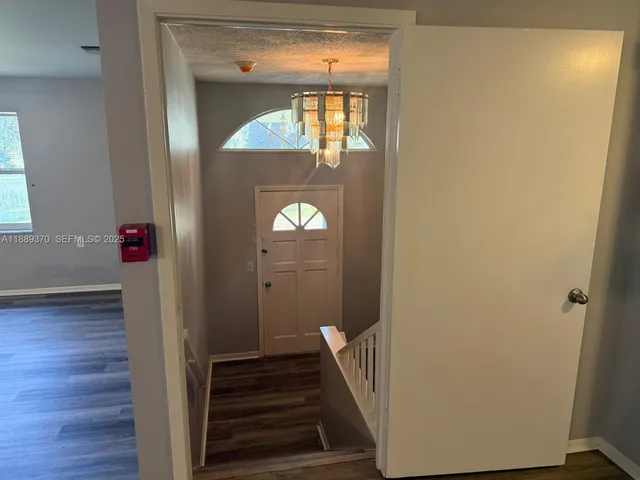 a view of a hallway with wooden floor and staircase