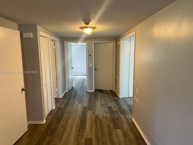 a view of a room with wooden floor and a bathroom