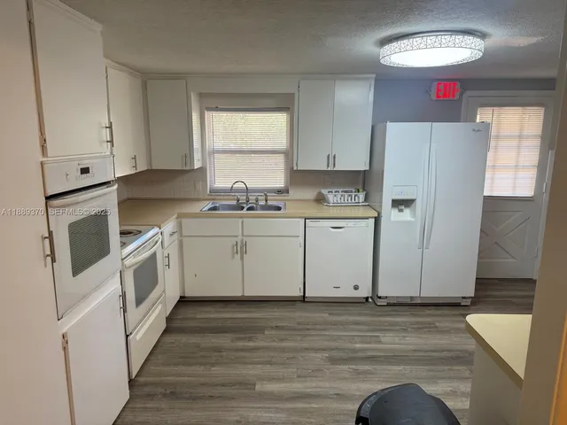 a kitchen with a sink cabinets appliances and a window