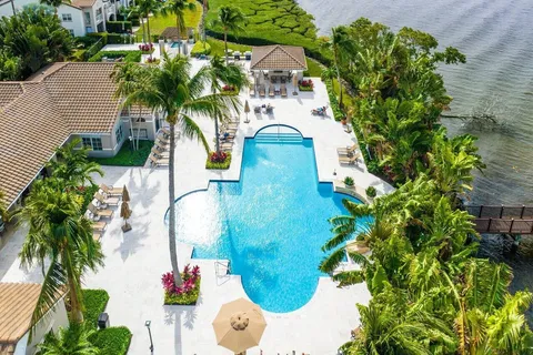 an aerial view of a house with a yard and large trees