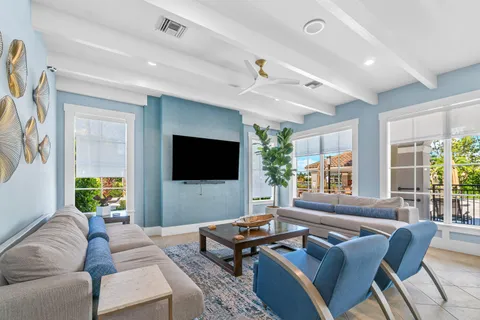 a living room with furniture a flat screen tv and a window