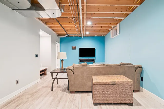 a living room with a bed furniture and a flat screen tv