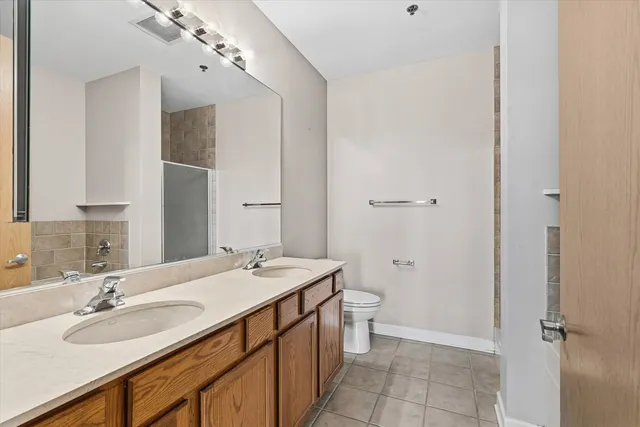 a bathroom with a double vanity sink mirror and toilet