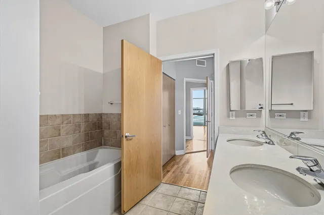a bathroom with a tub sink and mirror