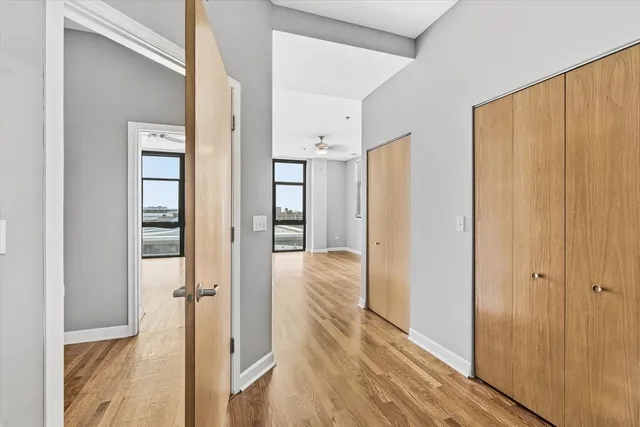 a view of a hallway with wooden floor and closet area
