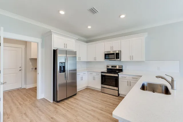 a kitchen with a refrigerator stove and wooden cabinets