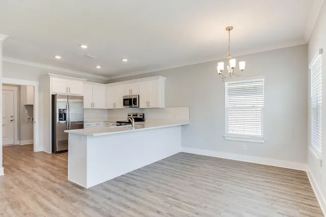 a view of kitchen with stainless steel appliances refrigerator oven and cabinets