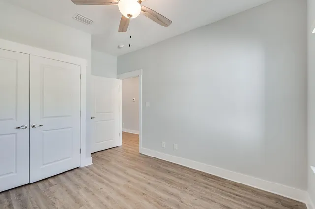 a view of an empty room with wooden floor