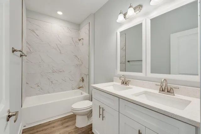 a bathroom with a sink a toilet and shower