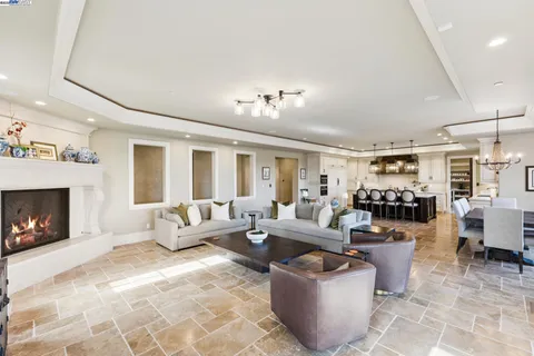 a large white kitchen with a large island oven a stove a sink a dining table and chairs