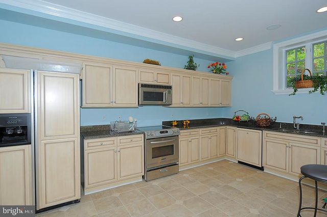 a kitchen with white cabinets stainless steel appliances and sink