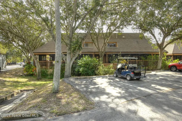 a view of a house with a large tree in front