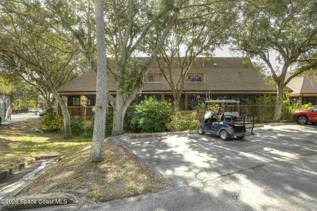 a view of a house with a large tree in front