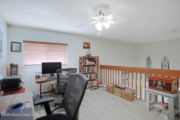 a view of a workspace with furniture and a window