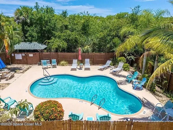 a view of a swimming pool with a patio and garden