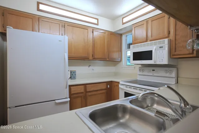 a kitchen with a sink a microwave and cabinets