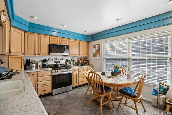 a kitchen with a table chairs microwave and cabinets