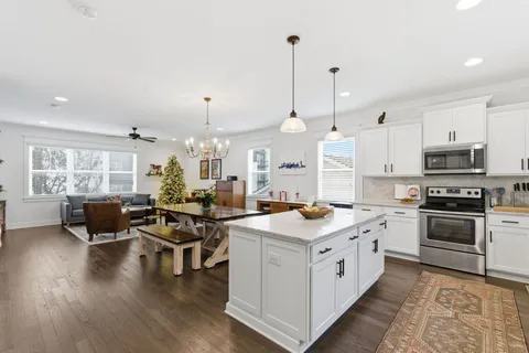 a kitchen with granite countertop white cabinets and stainless steel appliances