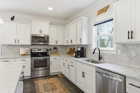 a kitchen with white cabinets and stainless steel appliances