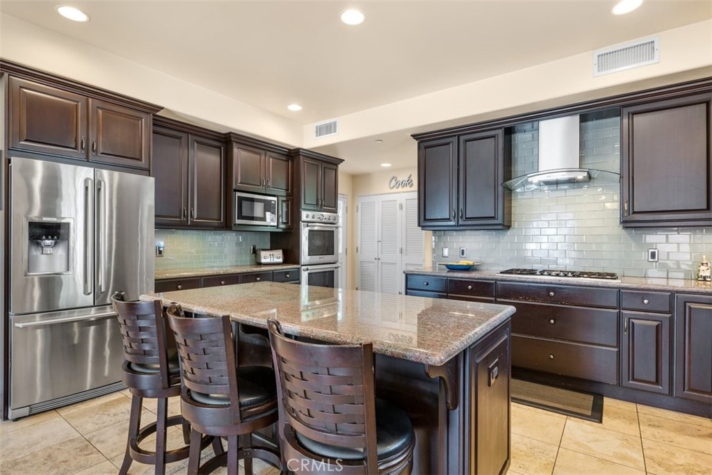 77 Altamont Way Camarillo, CA 93010 - Photo 10 of 48 a kitchen with granite countertop a table chairs microwave and refrigerator