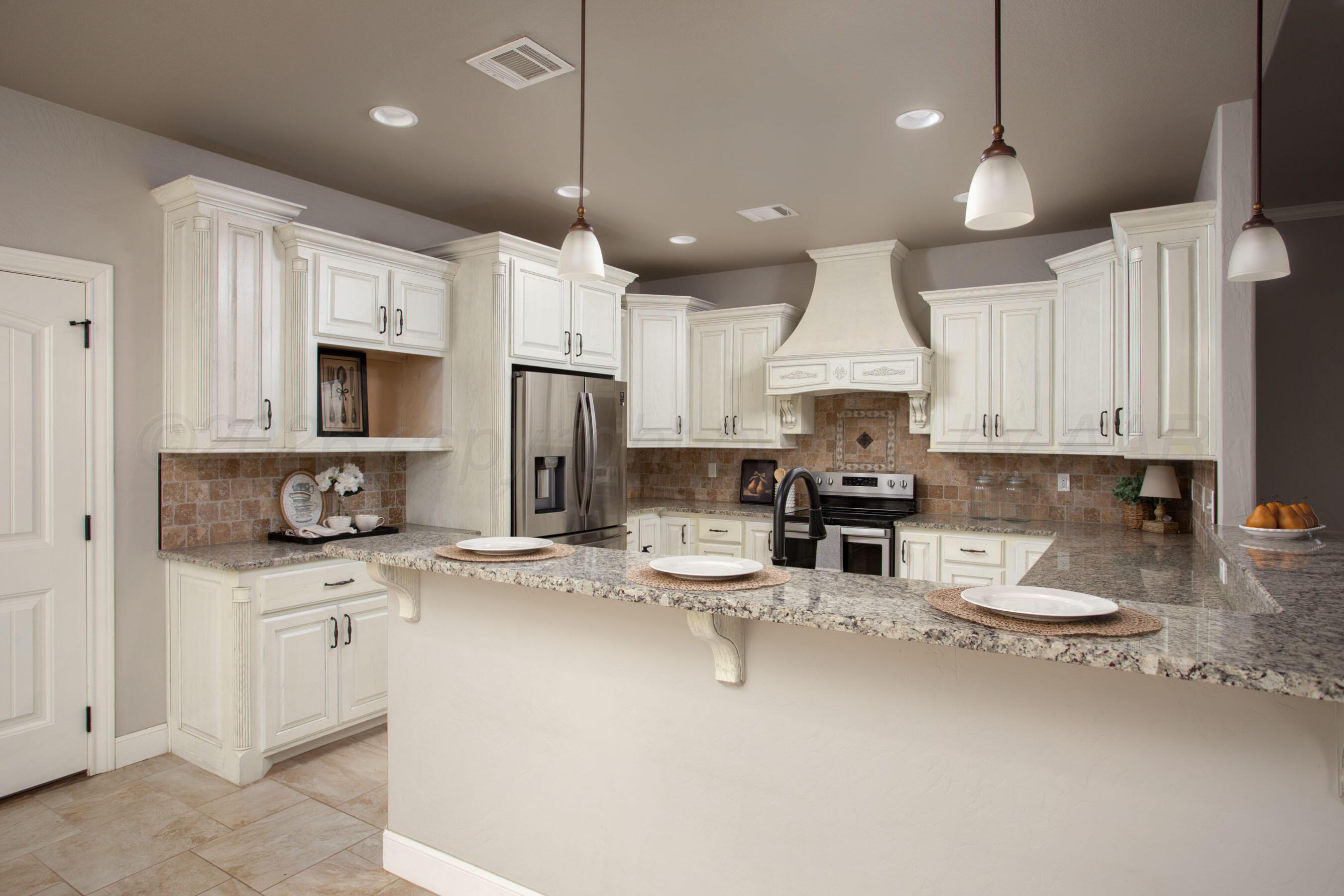9551 Yesterday Lane Amarillo, TX 79119 - Photo 12 of 53 a kitchen with granite countertop a stove a sink and a refrigerator