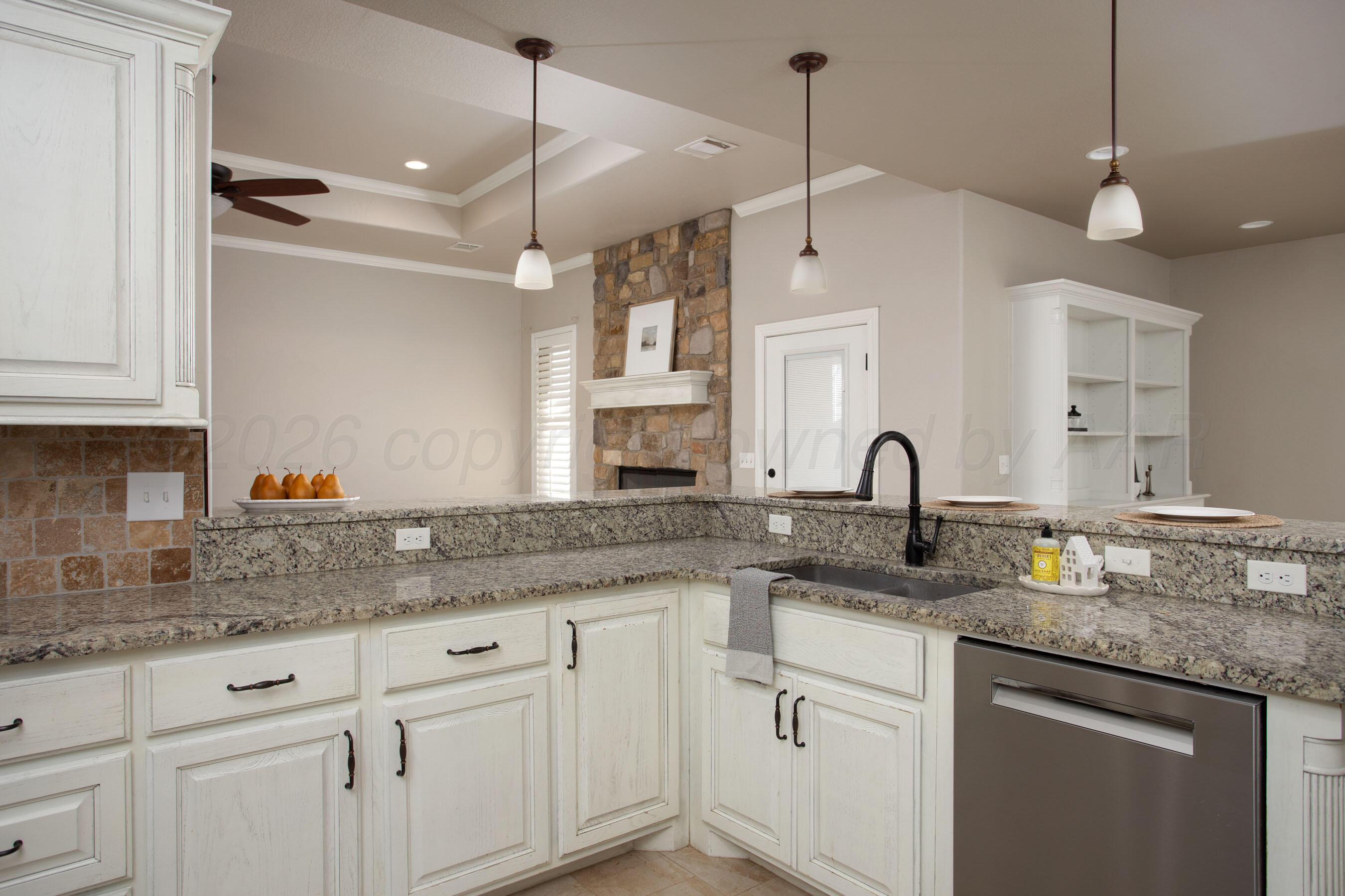 9551 Yesterday Lane Amarillo, TX 79119 - Photo 13 of 53 a kitchen with granite countertop a sink white cabinets and white stainless steel appliances