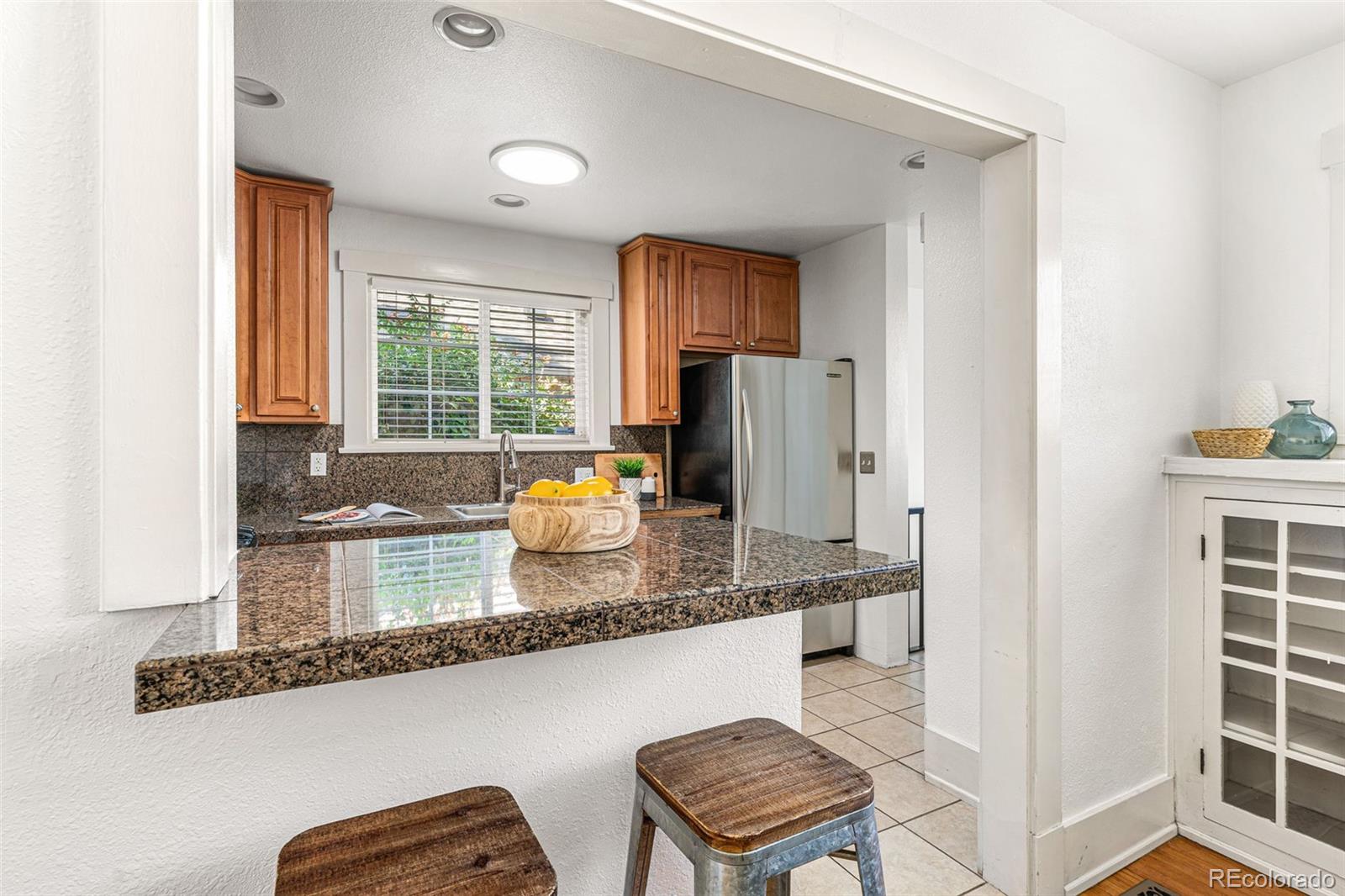 954 Jackson Street Denver, CO 80206 - Photo 4 of 37 a kitchen with granite countertop a stove a sink and a refrigerator