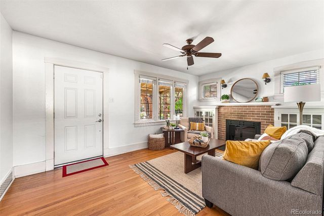 a living room with furniture a fireplace and a ceiling fan