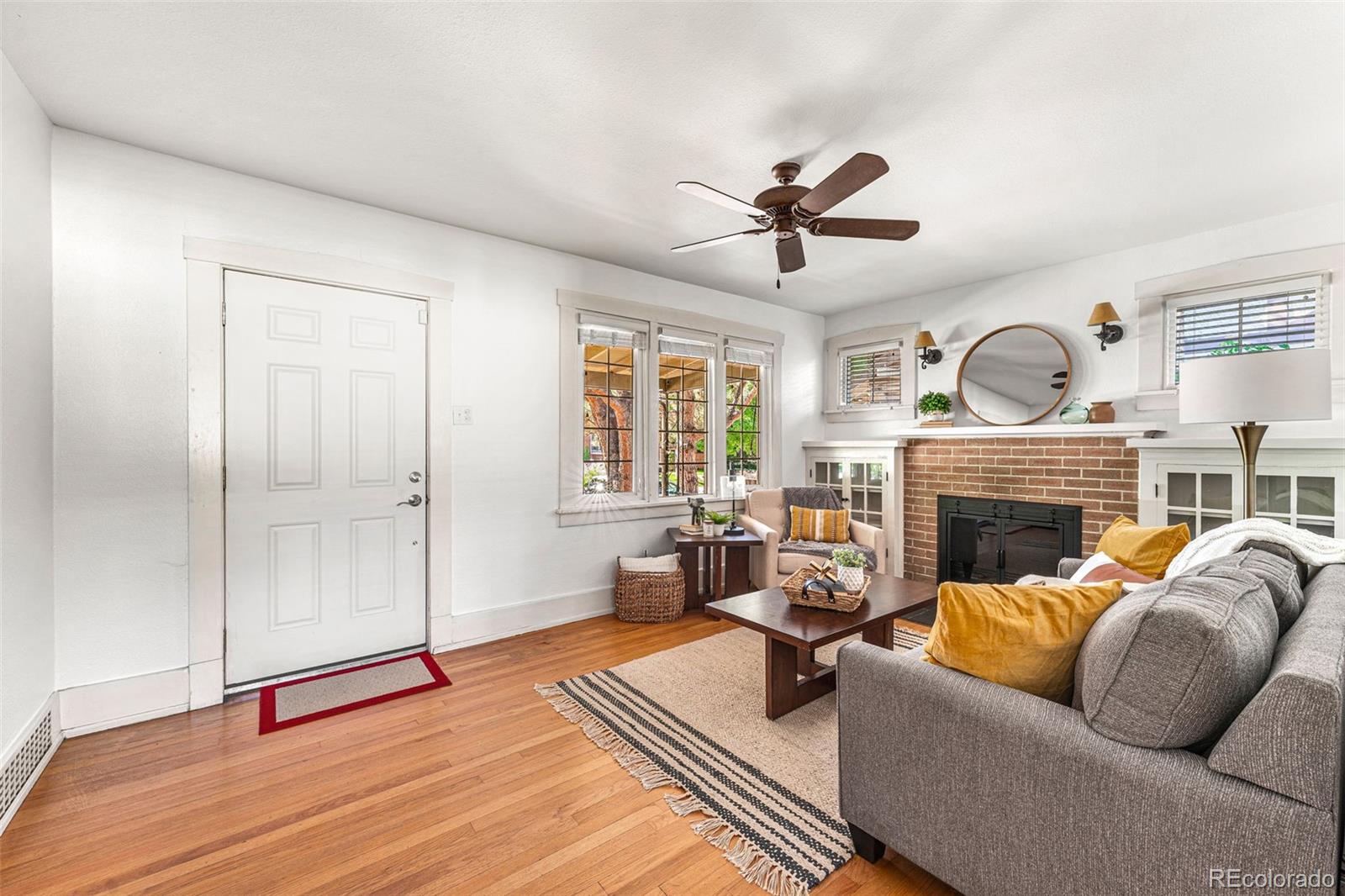 954 Jackson Street Denver, CO 80206 - Photo 7 of 37 a living room with furniture a fireplace and a ceiling fan
