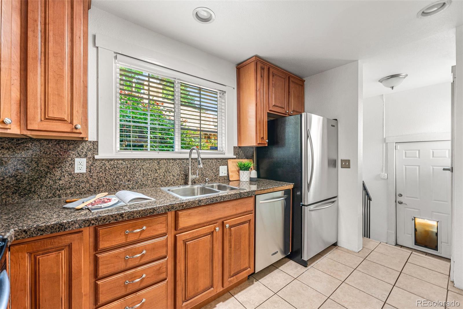954 Jackson Street Denver, CO 80206 - Photo 10 of 37 a kitchen with granite countertop a refrigerator and a sink