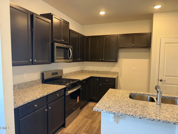 a kitchen with granite countertop stainless steel appliances and wooden cabinets