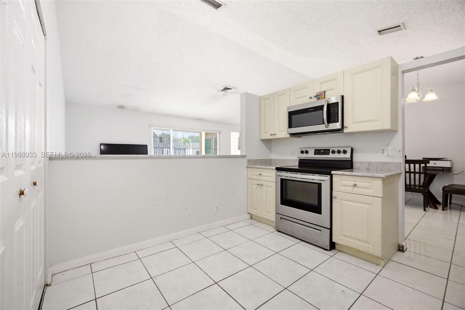 841 Southwest 55th Avenue Margate, FL 33068 - Photo 10 of 26 a kitchen with granite countertop white cabinets and appliances