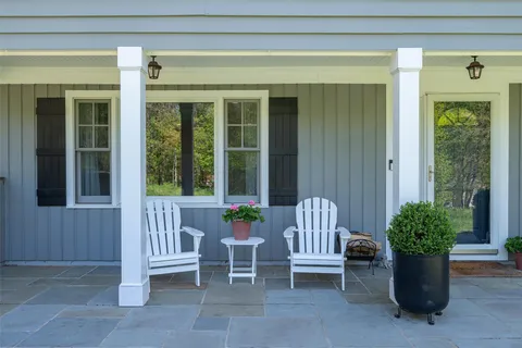 a view of a house with a porch and furniture