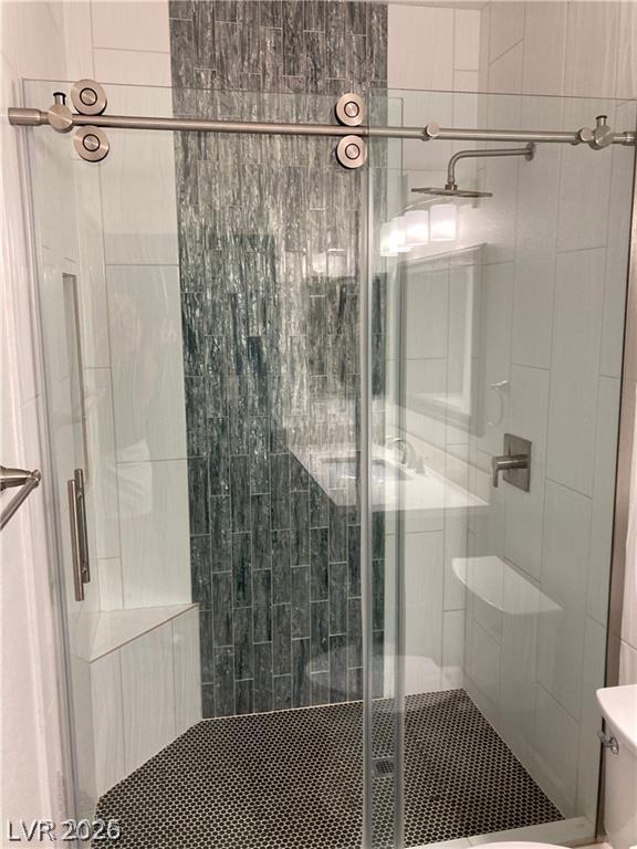 9050 West Warm Springs Road, Unit 1027 Las Vegas, NV 89148 - Photo 27 of 44 A modern shower with textured wall tiles and a sleek glass enclosure.