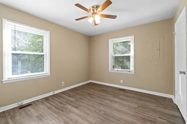 a view of a big room with wooden floor and windows