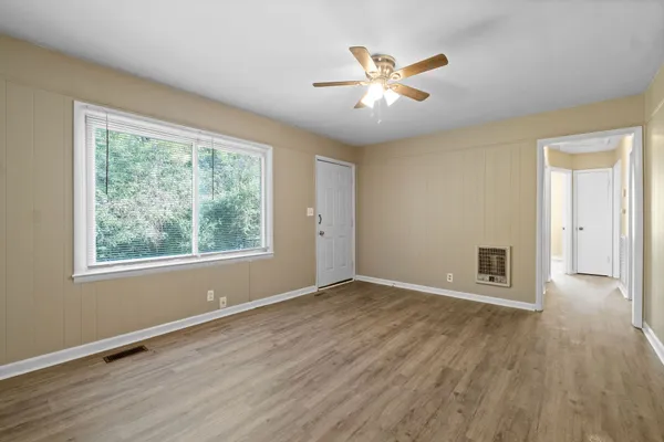 a view of a livingroom with wooden floor and a ceiling fan