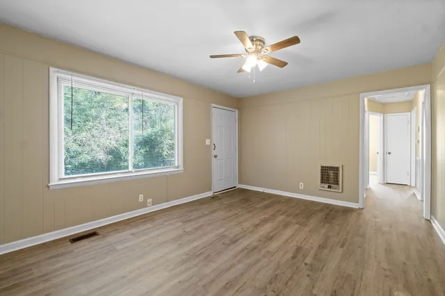 a view of a livingroom with wooden floor and a ceiling fan