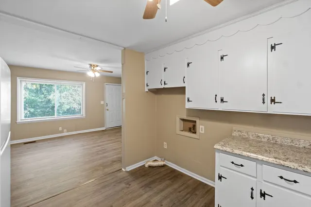 an empty room with wooden floor and cabinet
