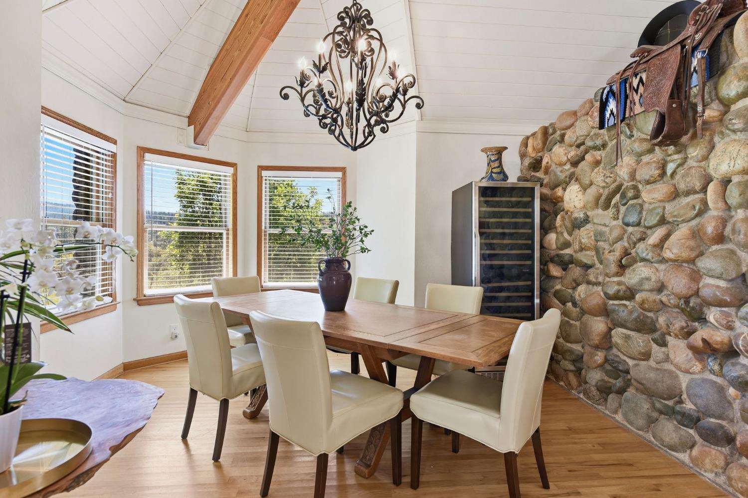7201 Happy Valley Road Somerset, CA 95684 - Photo 11 of 75 The dining area is separated by another river rock wall to delineate the space and has a fabulous chandelier and a bay window for morning sunlight.