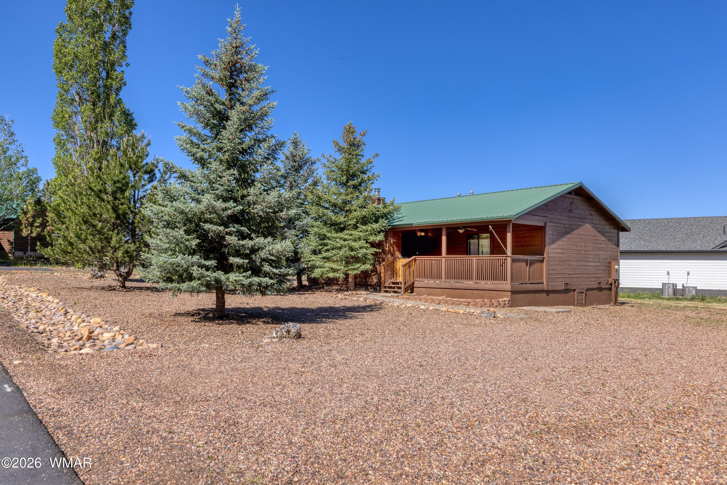 2722 Bain Trail Overgaard, AZ 85933 - Photo 15 of 28 a front view of a house with a yard and garage